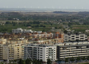 In this view, looking out over and past Lleida, you can see the tall turbines of a large wind farm in the distance.